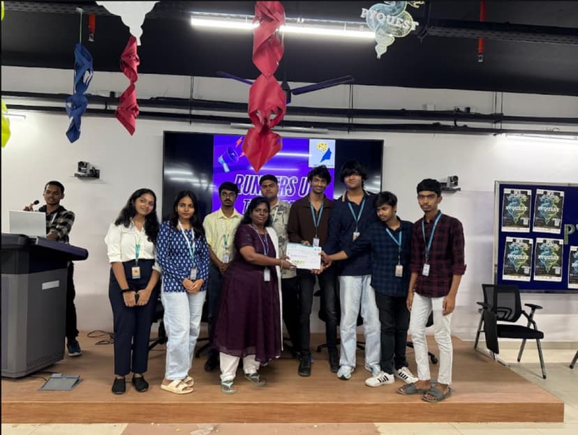 PyQuest 2025 winners on stage with a faculty member